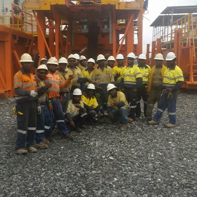 Zenex Drilling team in safety gear in front of mine drilling machinery in Papua New Guinea